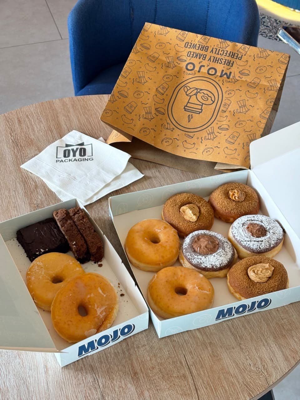 Mojo doughnuts and brownies in two open boxes